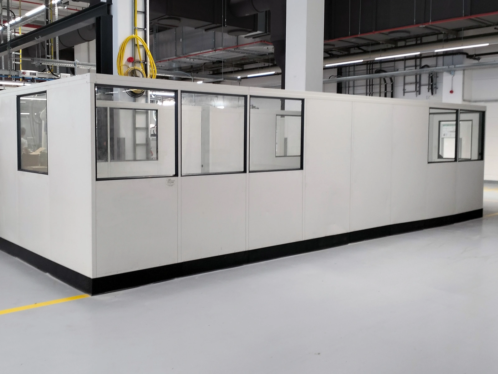 Stellwand als Einhausung in einer Produktionshalle Stellwand als Einhausung in der Industrie zur geschätzten Produktion